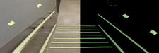 AI-colorized stairway application illustration showing photoluminescent tape markings in light and darkness. Glow appearance is illustrative and varies with charging conditions.